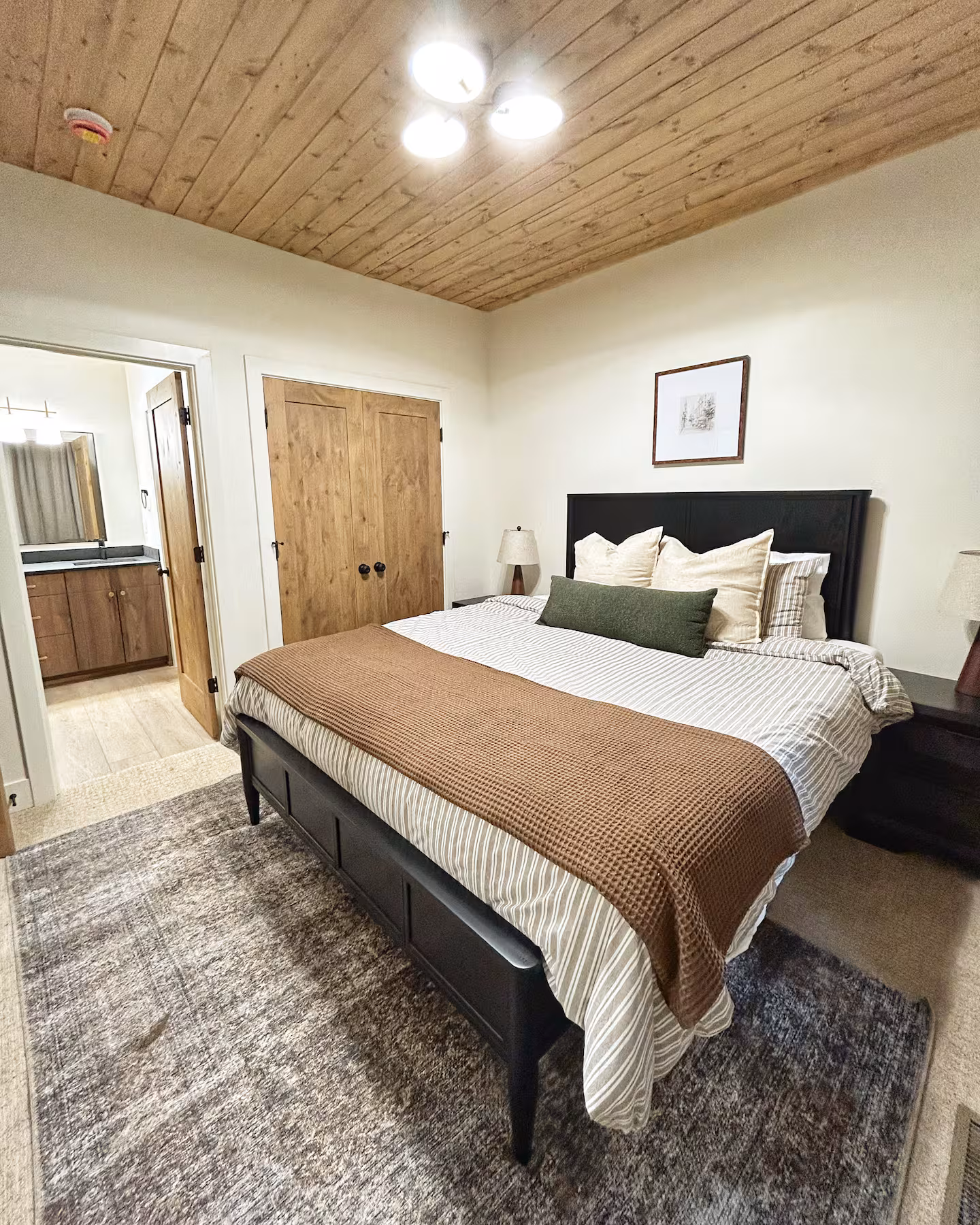 King bedroom with wood ceiling and ensuite bath